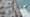 On the left we see a stack of $100 bills, on the right we see a large passenger airplane in flight.